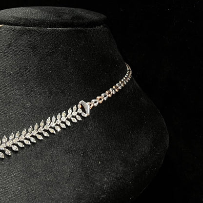 Diamond necklace set framed by diamond leaves and cascading diamond drops on a mannequin bust from left side.