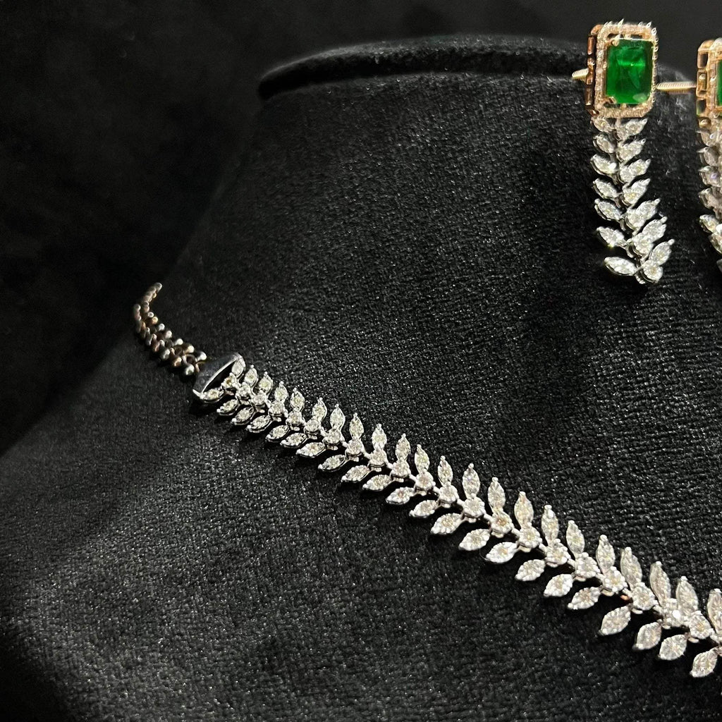 Diamond necklace set framed by diamond leaves and cascading diamond drops, paired with matching earrings on a mannequin bust from right side.