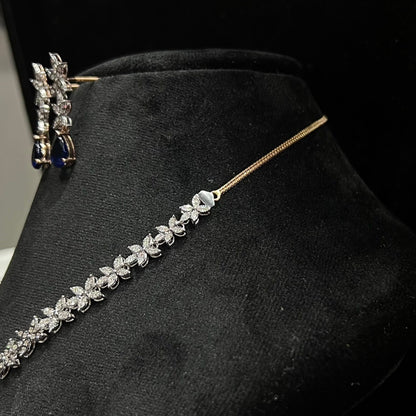 Diamond necklace set with color stone drop pendant and matching floral diamond earrings displayed on black stand from left side.