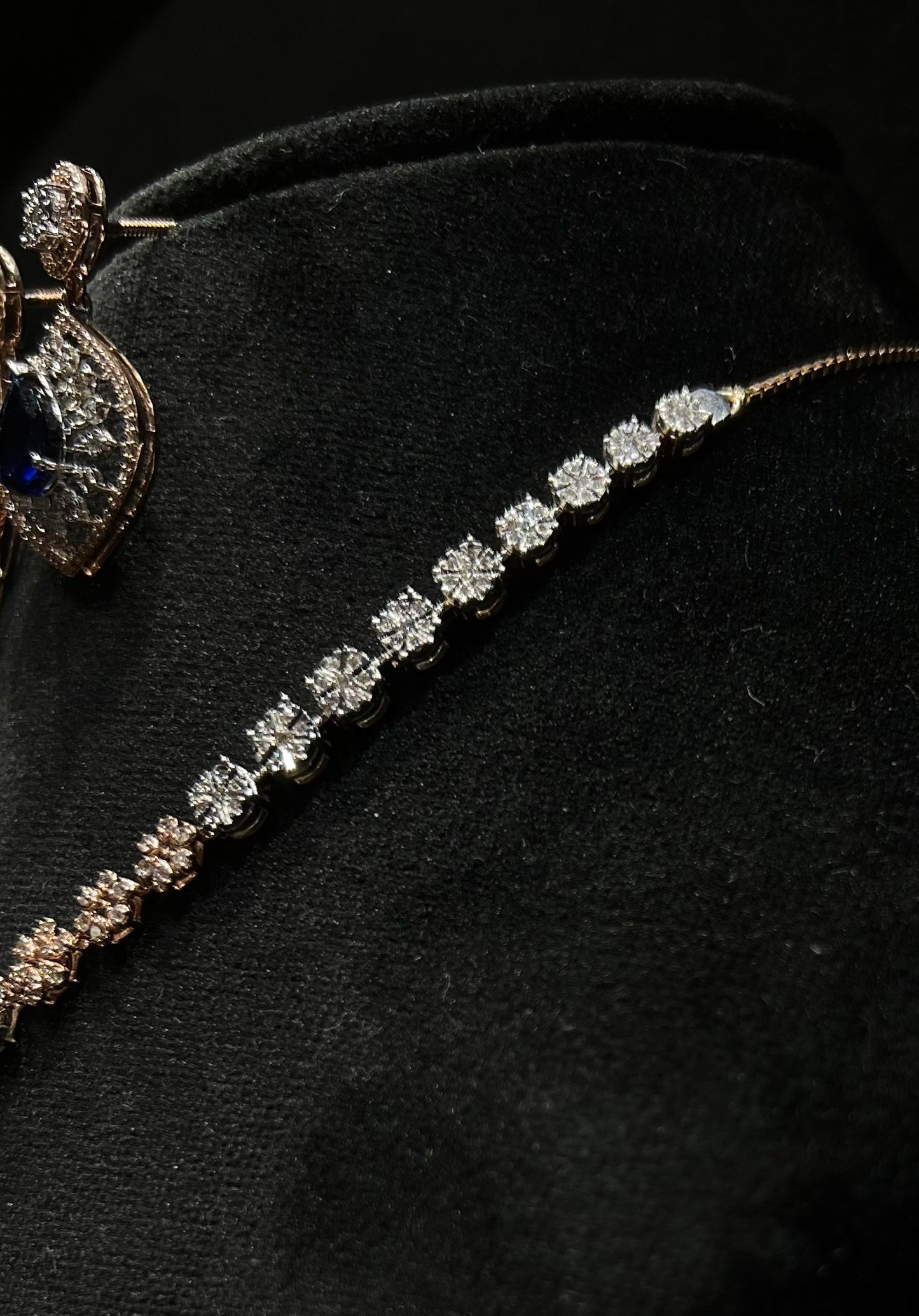 Floral design diamond necklace set with matching earrings, featuring a pear-shaped blue stone drop surrounded by natural diamonds.