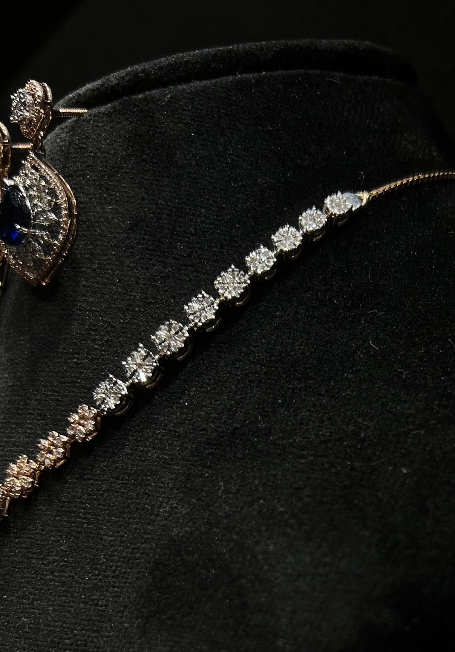 Floral design diamond necklace set with matching earrings, featuring a pear-shaped blue stone drop surrounded by natural diamonds.