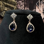 Close-up of color stone and diamond earrings from diamond necklace set with floral top design displayed on a mannequin bust.