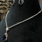 Side view of diamond necklace set featuring color stone teardrop pendant and delicate chain with matching earrings