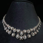 A 14K gold diamond necklace set displayed on a mannequin bust, featuring a solid gold structure with diamond encrusted in the necklace.