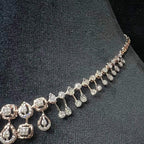 A gold diamond necklace is displayed on a mannequin bust.