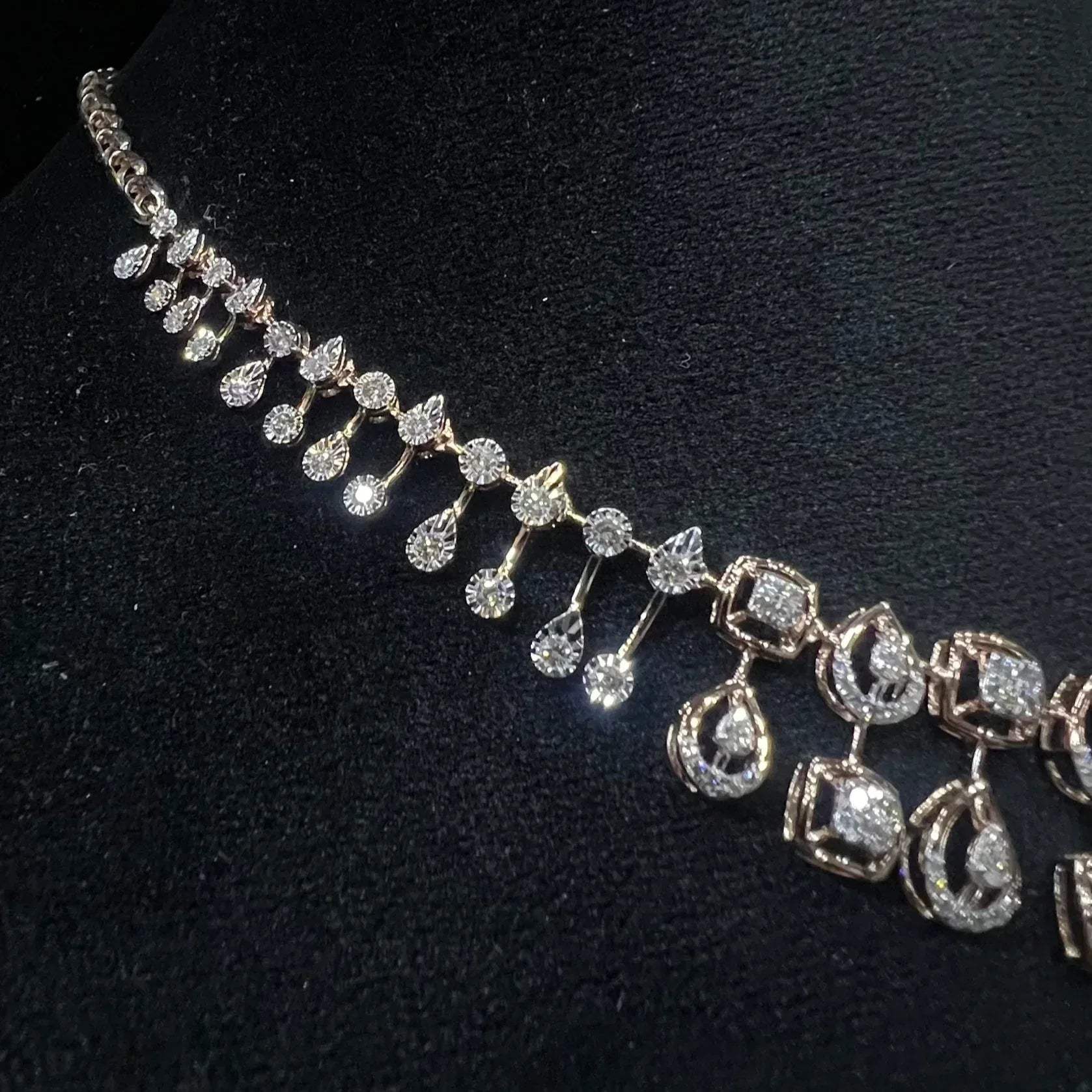 A gold diamond necklace is displayed on a mannequin bust
