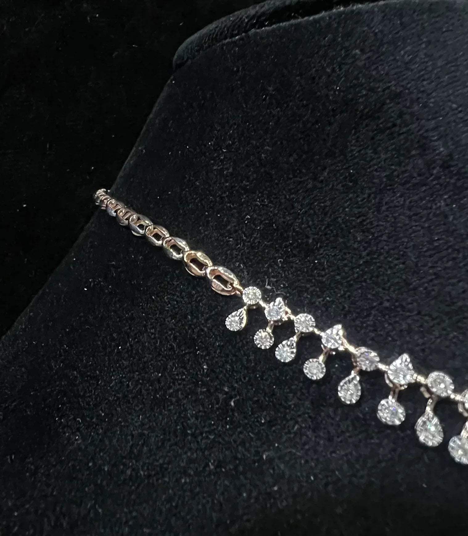 A diamond necklace displayed on a mannequin bust, featuring a solid gold structure with diamond encrusted in the necklace.