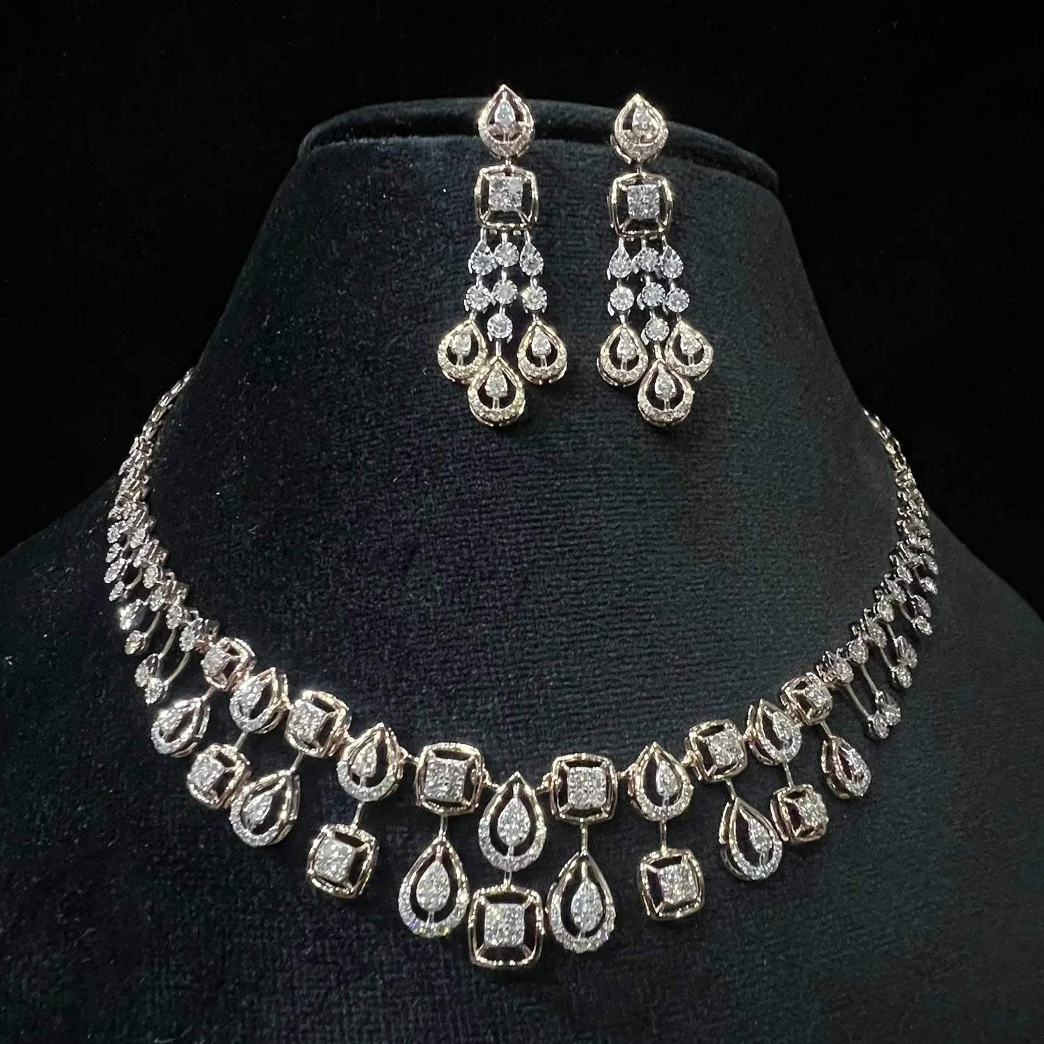 A gold diamond necklace and earrings set displayed on a mannequin bust, featuring a solid gold structure with diamond encrusted in the earrings and necklace.