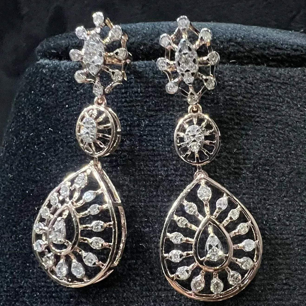 Elegant teardrop-shaped diamond  earrings with floral-inspired motifs displayed on a black background.
