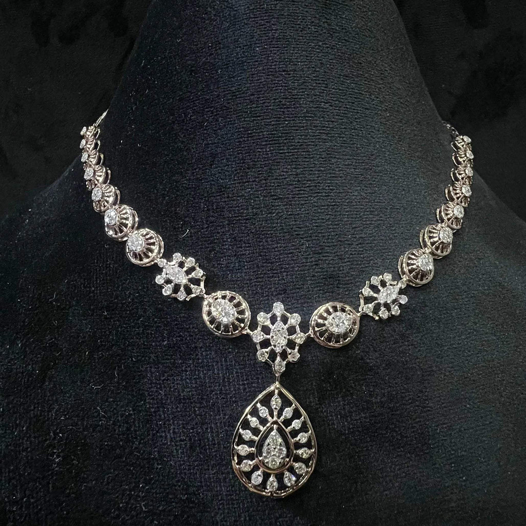 Elegant teardrop-shaped diamond  necklace with floral-inspired motifs displayed on a black background.