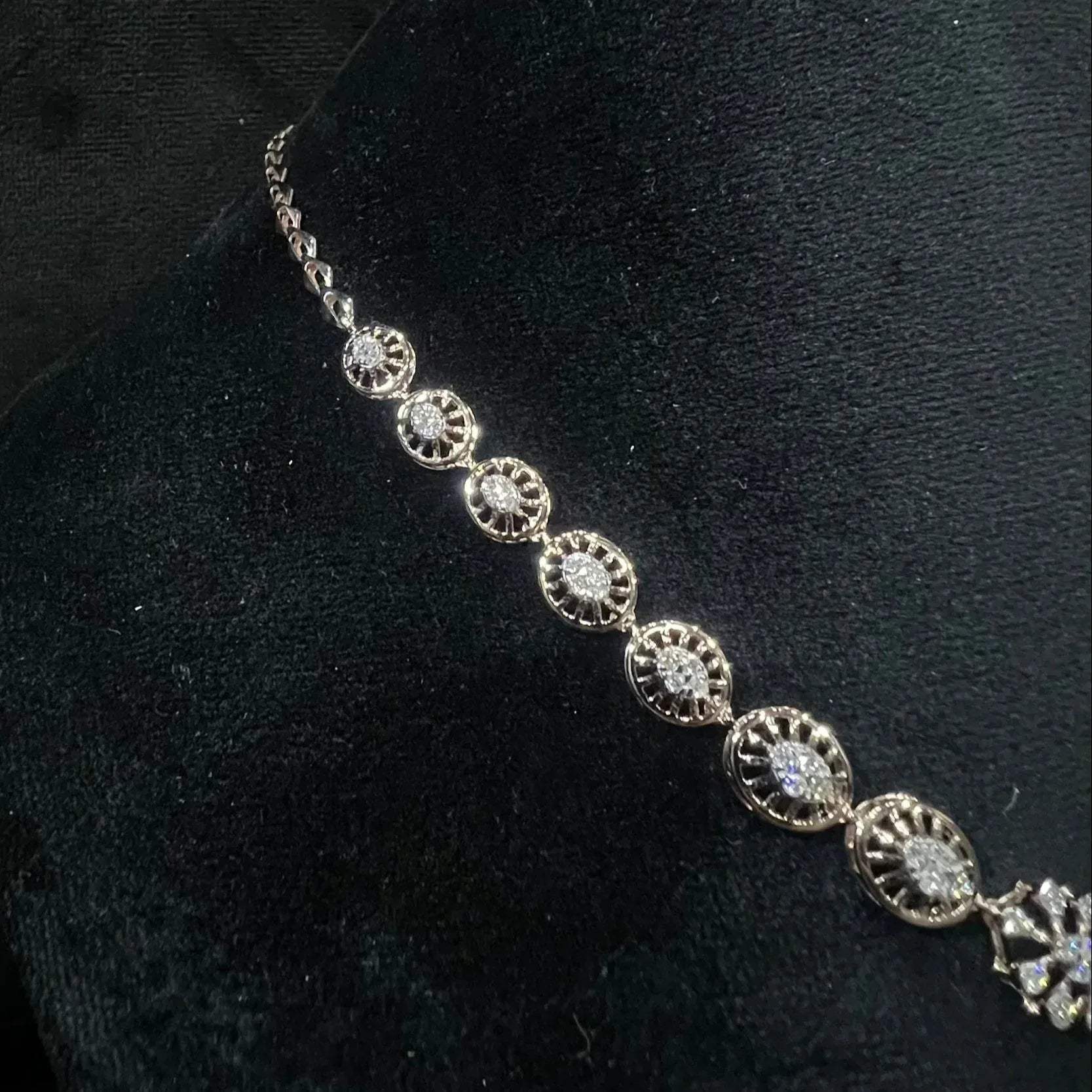 Elegant teardrop-shaped diamond necklace set with floral-inspired motifs displayed on a black background.