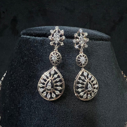 Elegant teardrop-shaped diamond  earrings with floral-inspired motifs displayed on a black background.