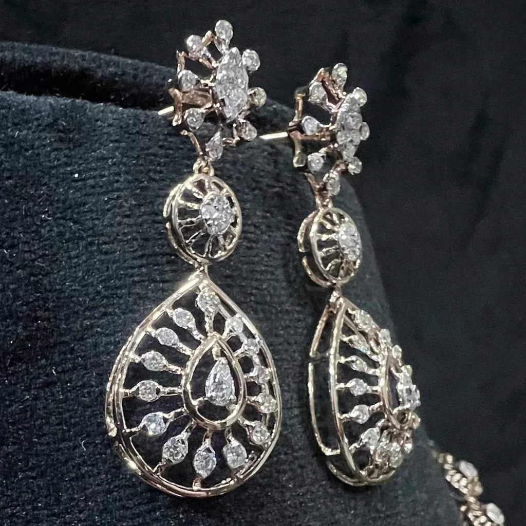 Elegant teardrop-shaped diamond  earrings with floral-inspired motifs displayed on a black background.