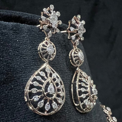Elegant teardrop-shaped diamond  earrings with floral-inspired motifs displayed on a black background.