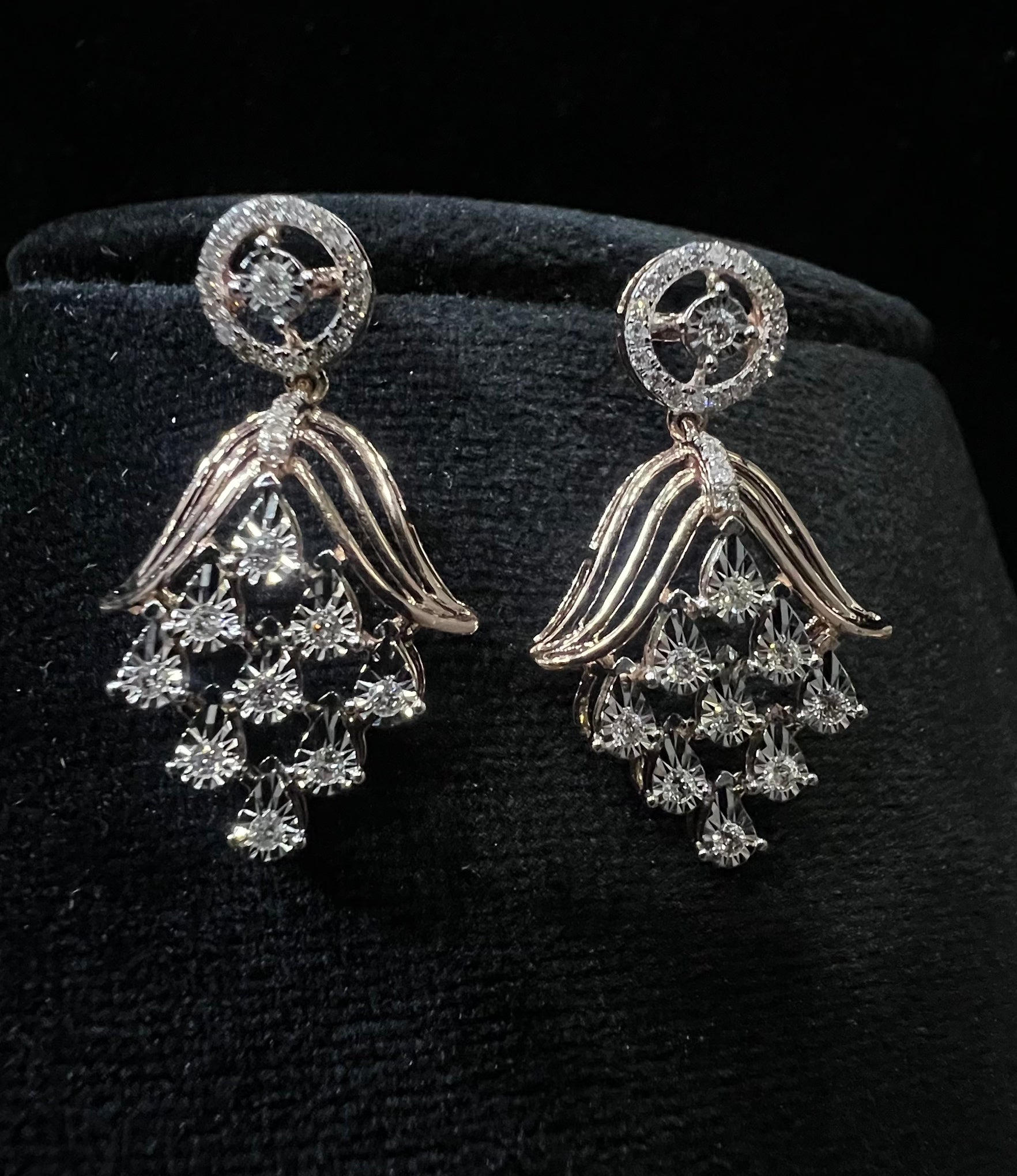 Radiant cascade diamond earrings displayed on black velvet bust
