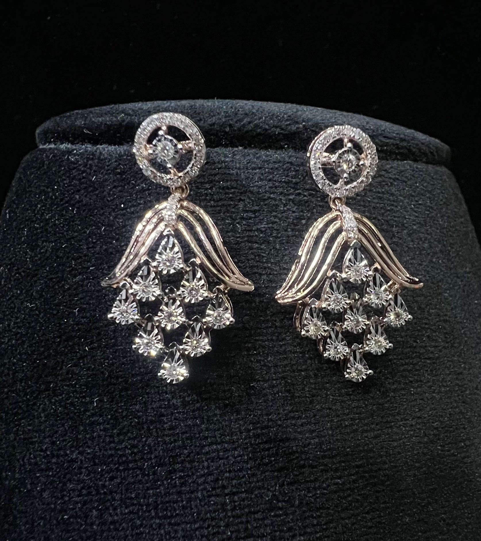 Radiant cascade diamond earrings displayed on black velvet bust