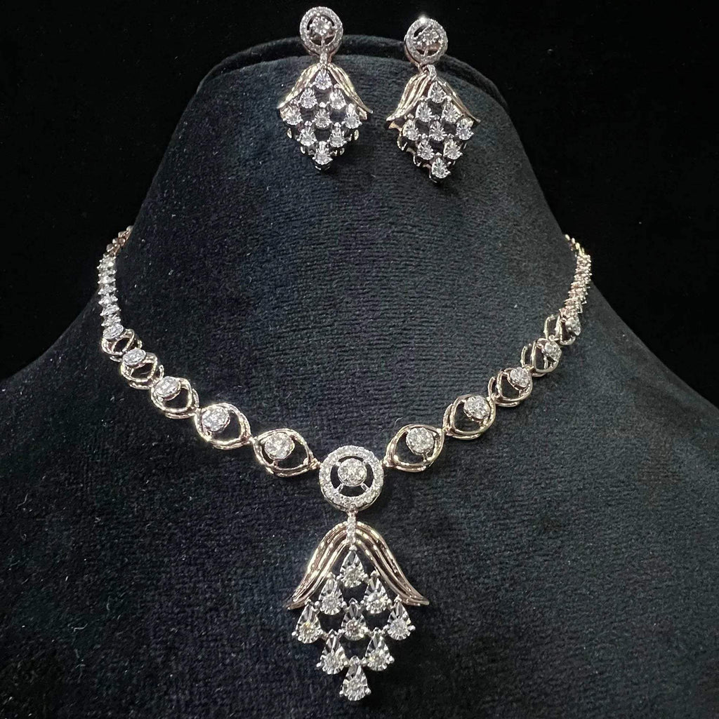 A gold diamond necklace with a geometric pattern and a pair of matching earrings, displayed on a black mannequin bust.