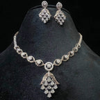 A gold diamond necklace with a geometric pattern and a pair of matching earrings, displayed on a black mannequin bust.