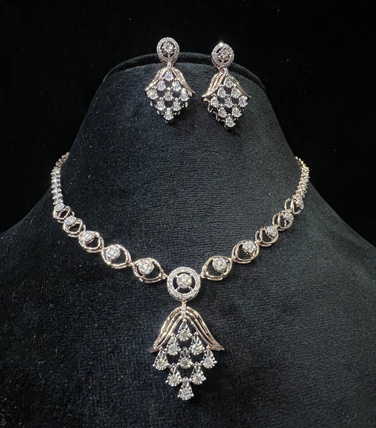 A gold diamond necklace with a geometric pattern and a pair of matching earrings, displayed on a black mannequin bust.