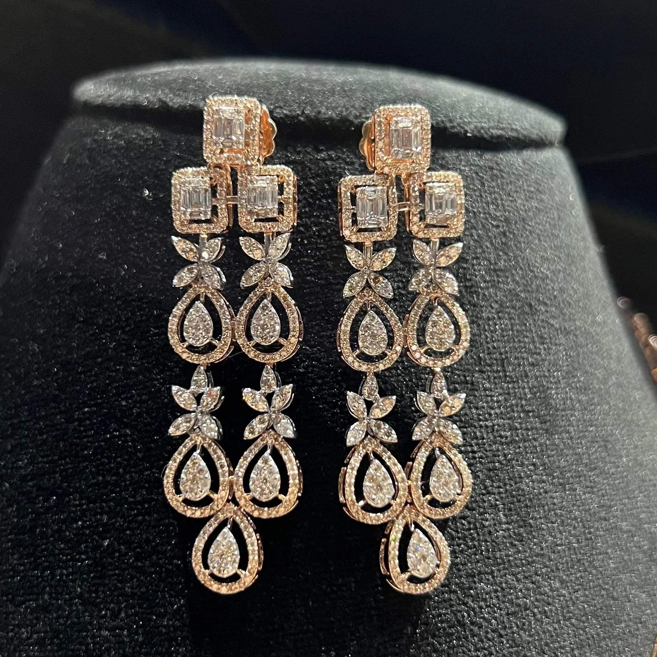Luxury floral motif diamond drop earrings on a mannequin bust.