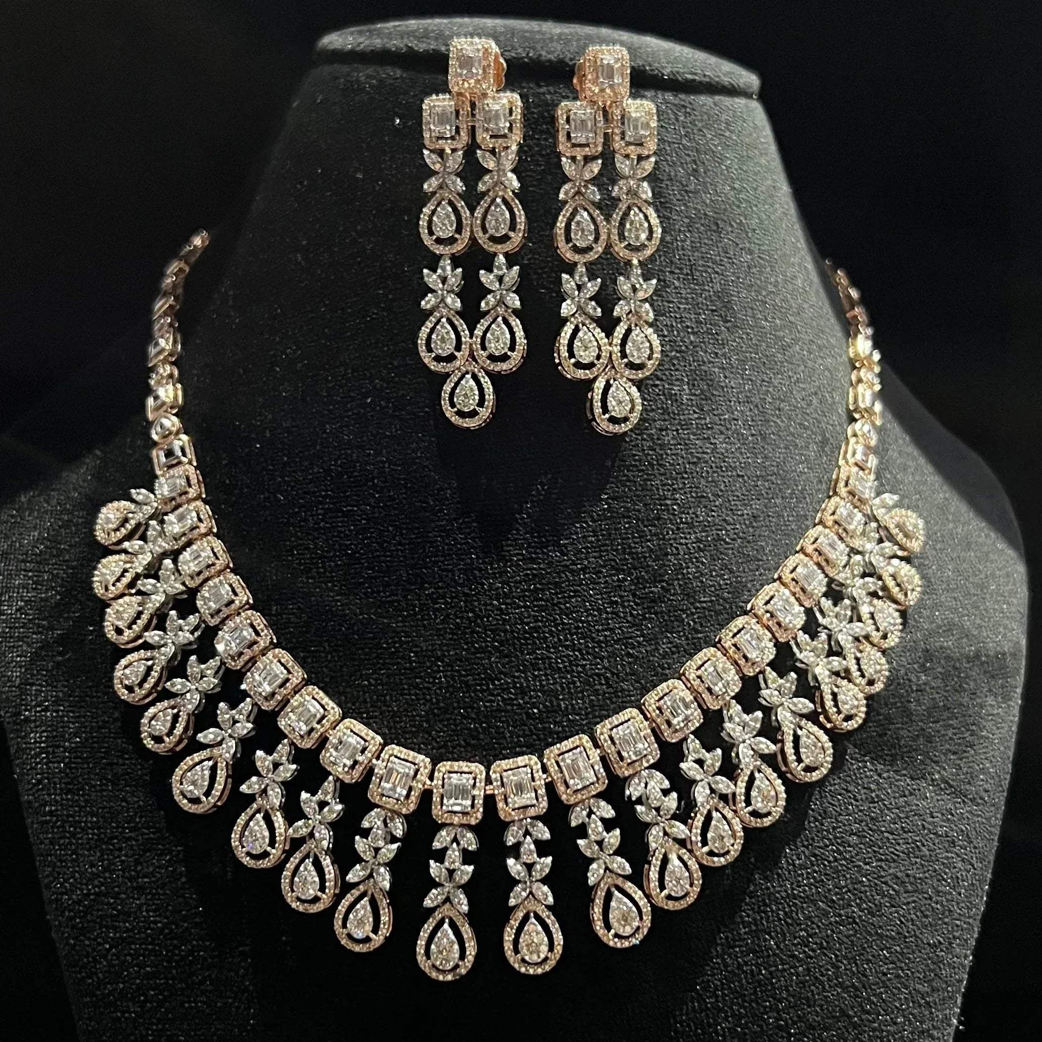 Luxury floral motif diamond necklace set with matching drop earrings on a mannequin bust.