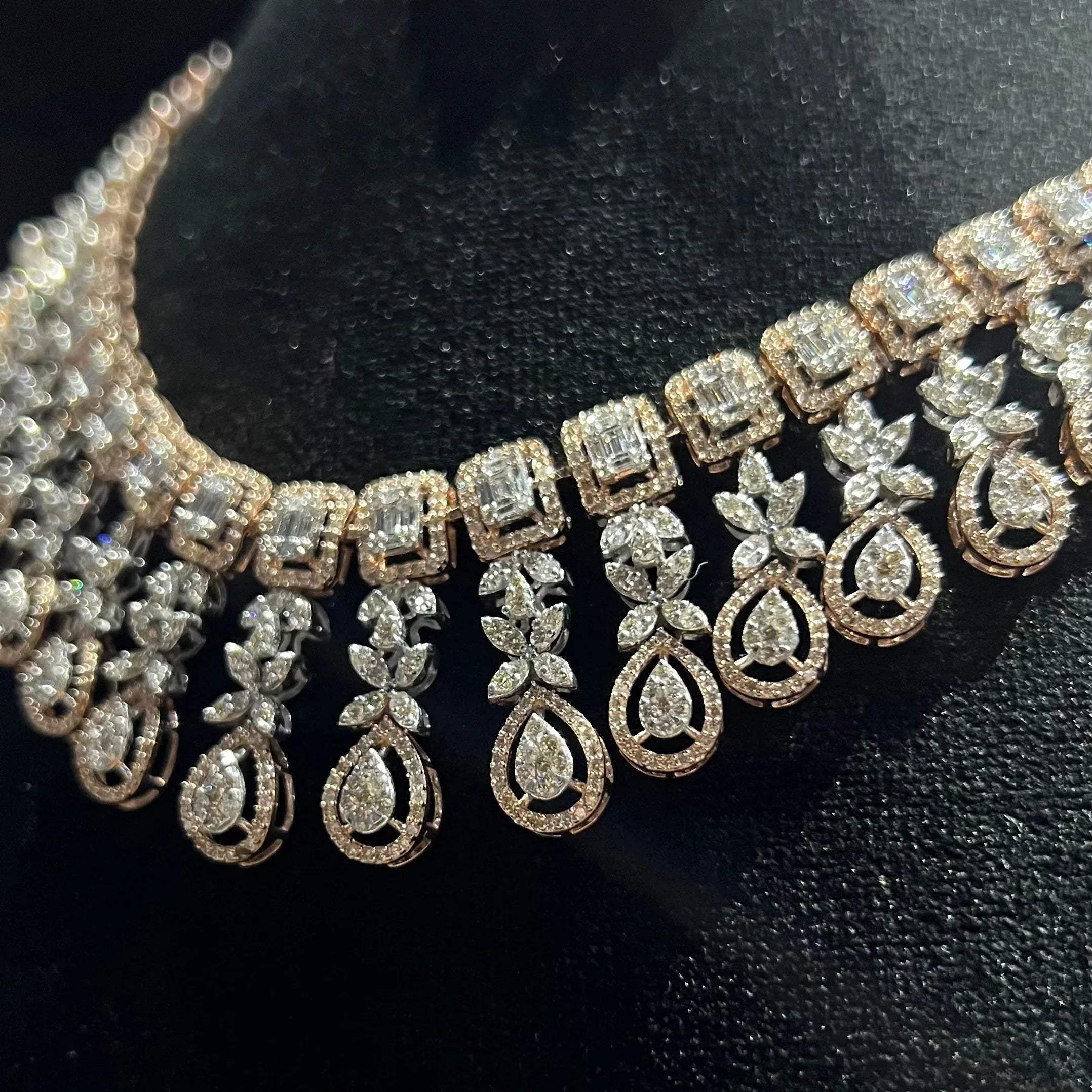 Luxury floral motif diamond necklace set with matching drop earrings on a mannequin bust.