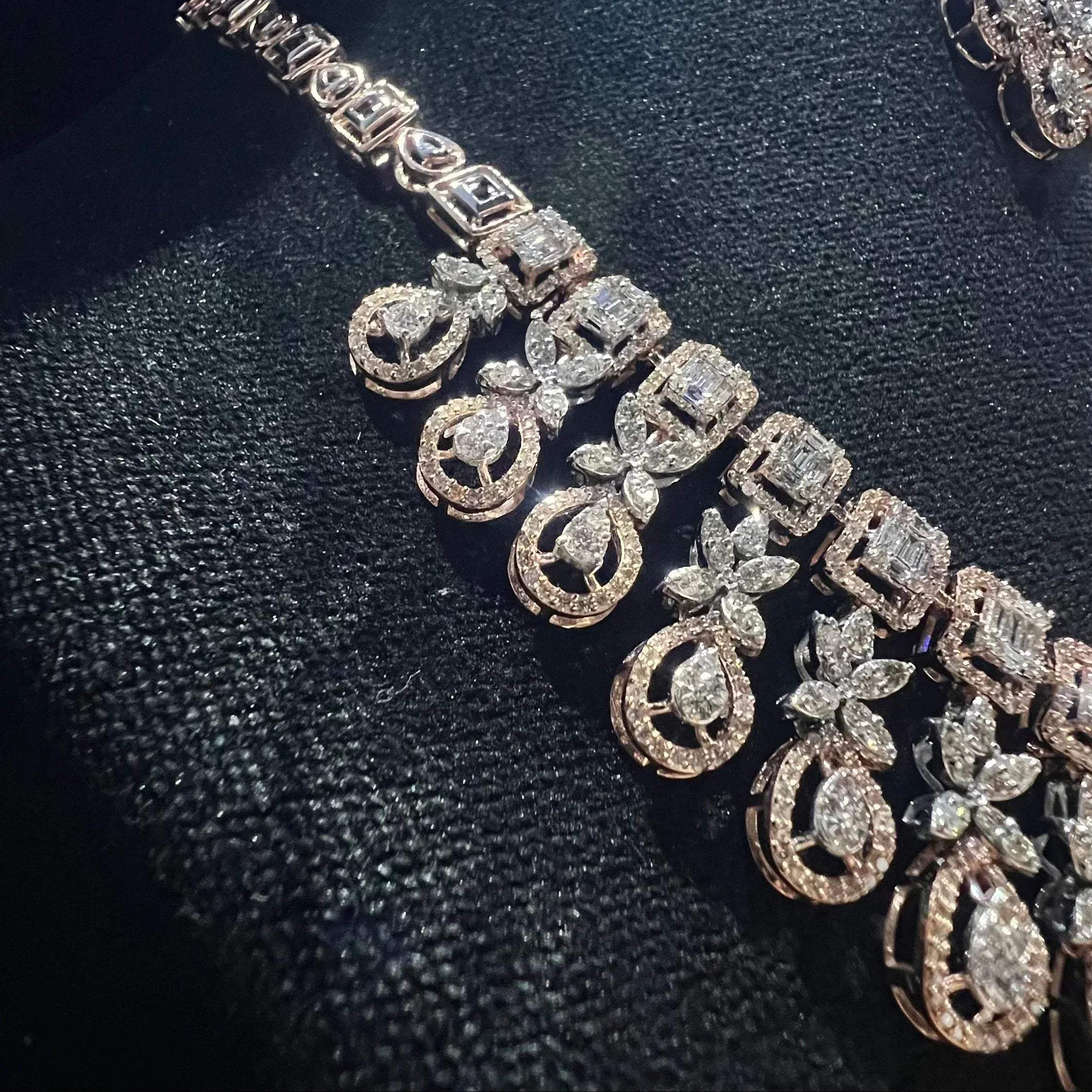 Luxury floral motif diamond necklace set with matching drop earrings on a mannequin bust.