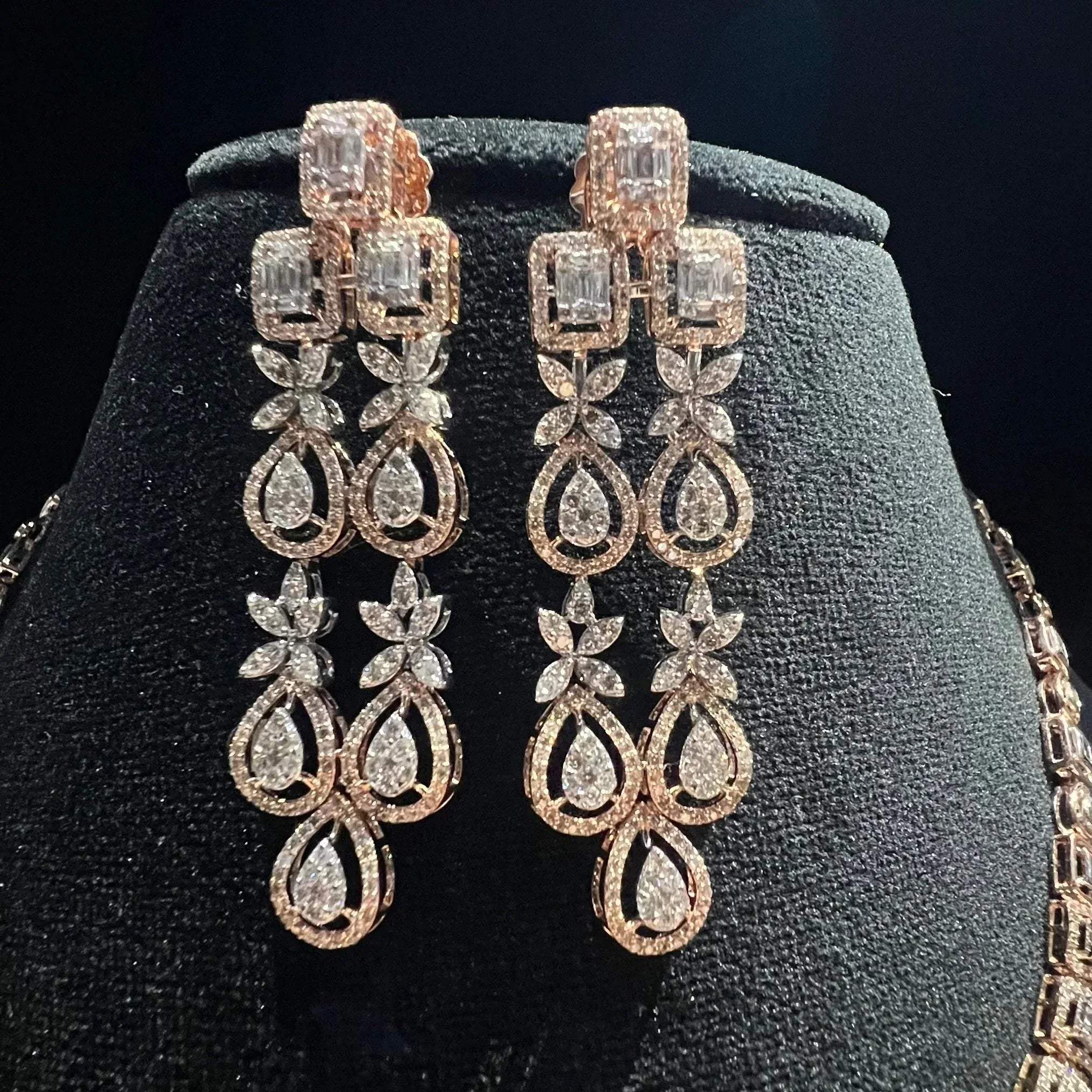 Luxury floral motif diamond necklace set with matching drop earrings on a mannequin bust.