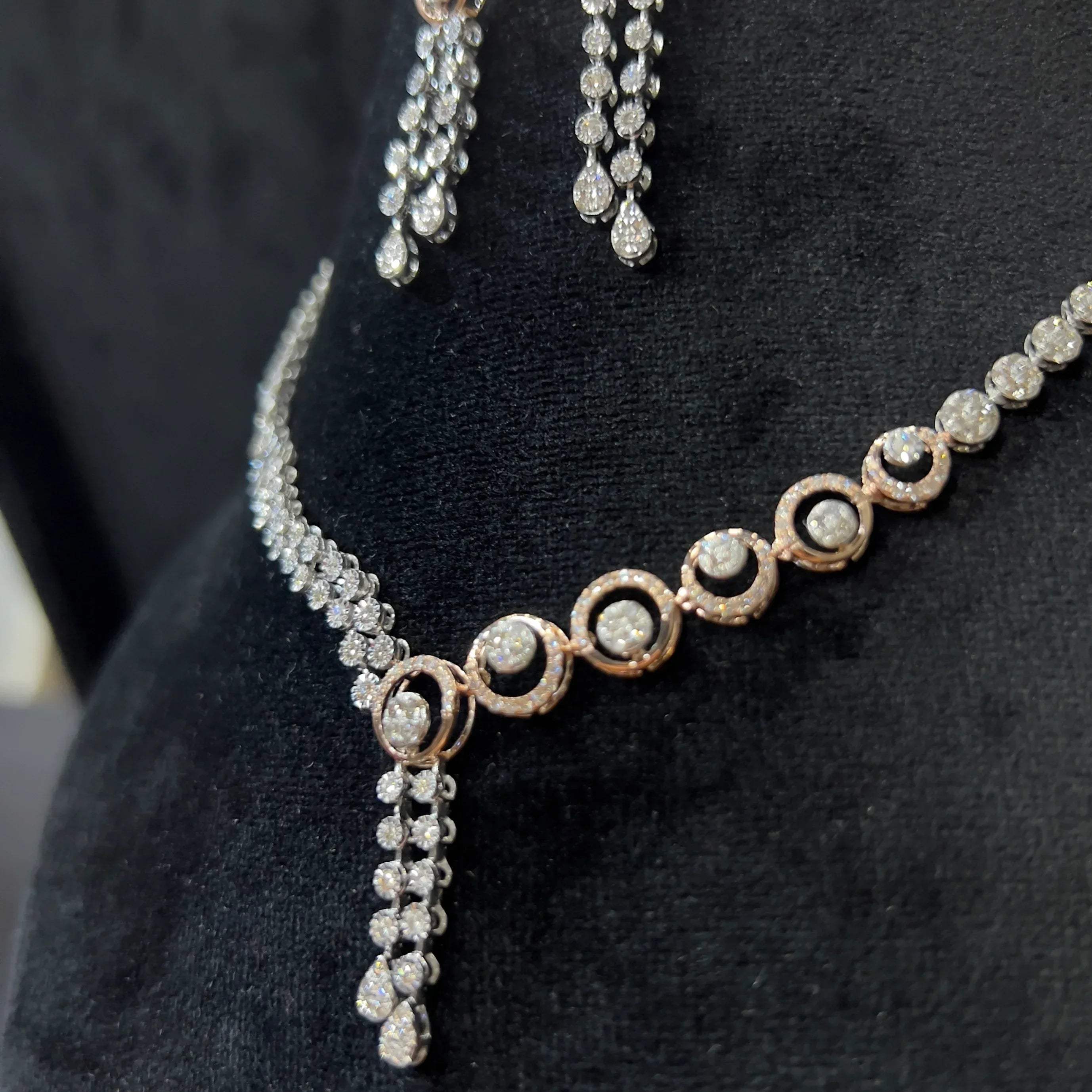 Diamond necklace set with circular motif design and matching drop earrings, featuring sparkling stones in elegant modern style.