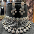 A gold diamond choker necklace with a matching set of earrings, adorned with brilliant cut diamonds, displayed on a mannequin.