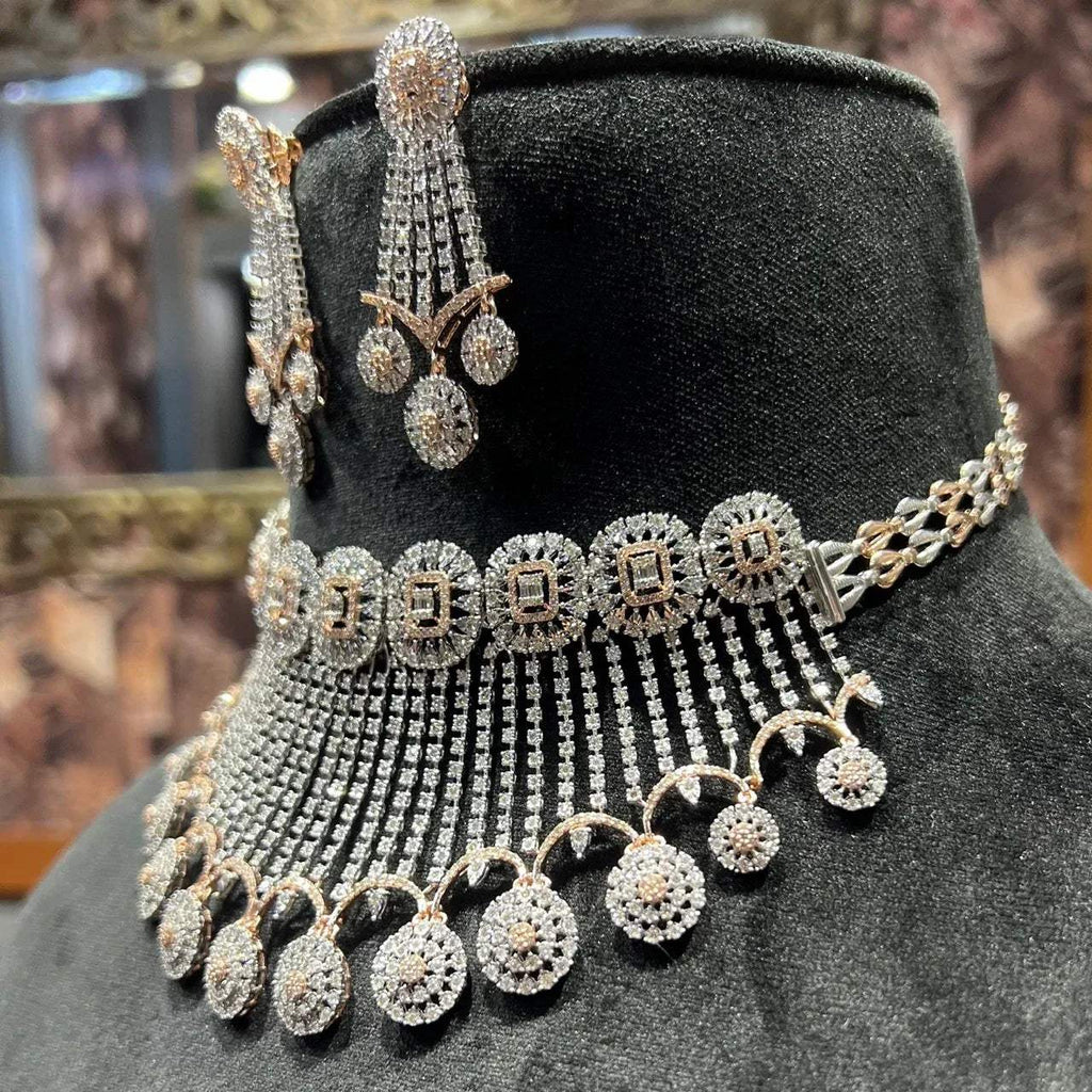 A gold diamond choker necklace with a matching set of earrings, adorned with brilliant cut diamonds, displayed on a mannequin.