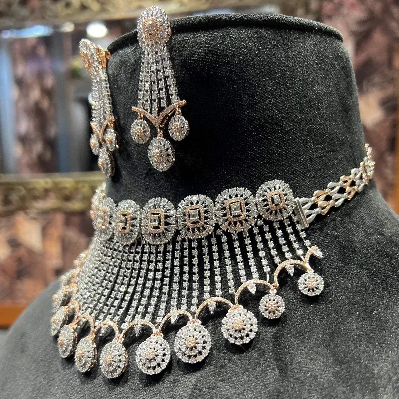 A gold diamond choker necklace with a matching set of earrings, adorned with brilliant cut diamonds, displayed on a mannequin.