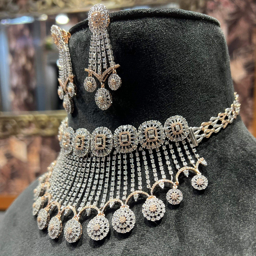 A gold diamond choker necklace with a matching set of earrings, adorned with brilliant cut diamonds, displayed on a mannequin.