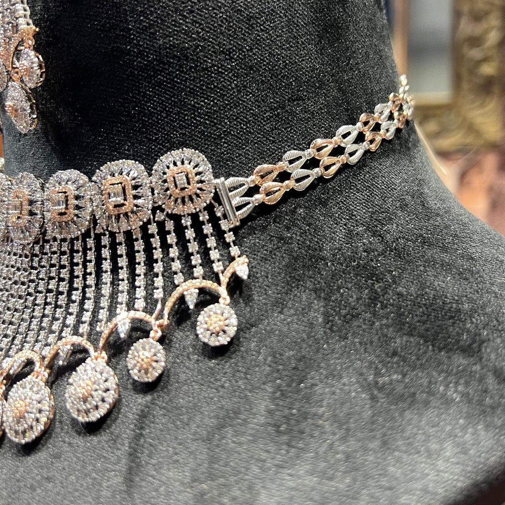A gold diamond choker necklace with a matching set of earrings, adorned with brilliant cut diamonds, displayed on a mannequin.