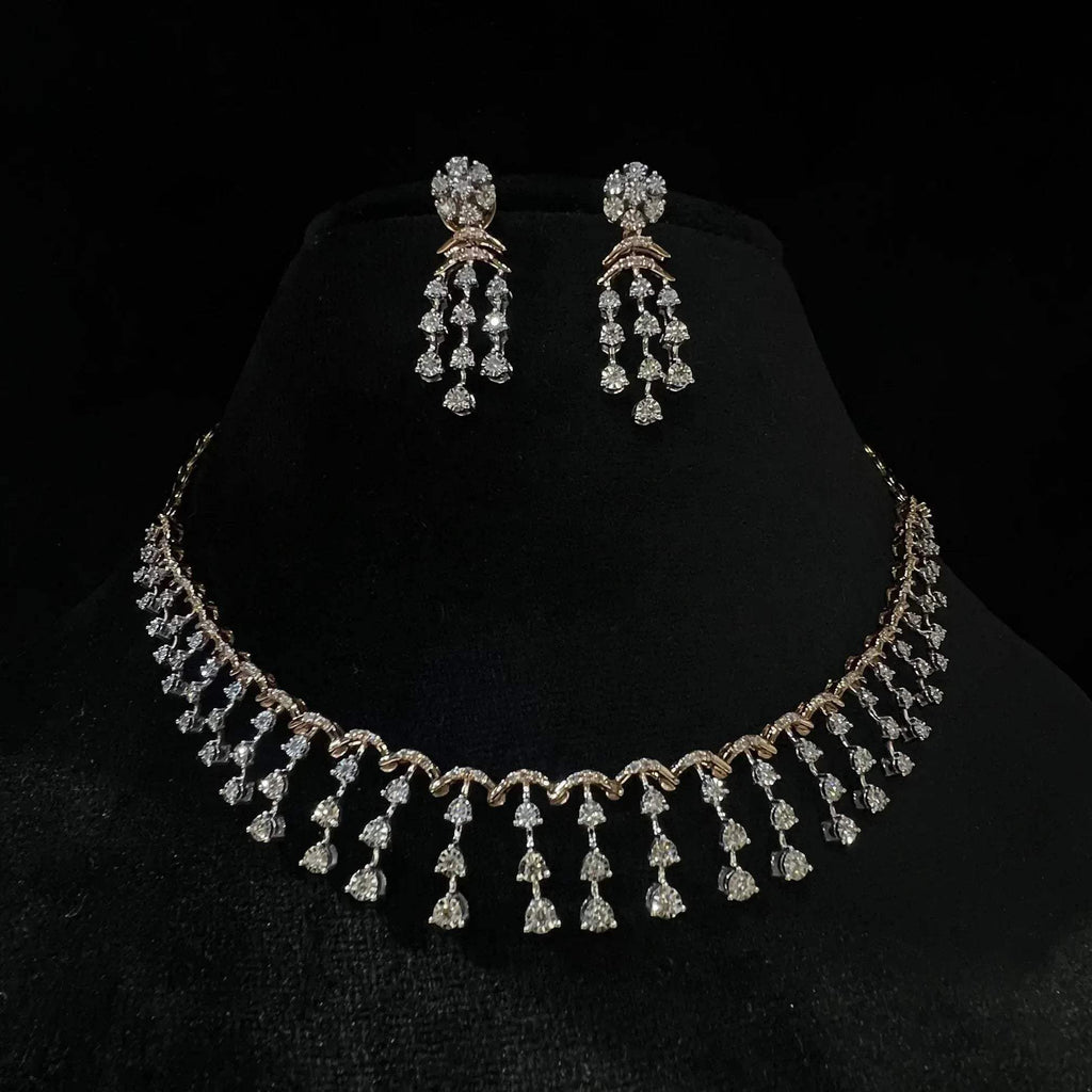 A gold diamond necklace with a series of round and marquise shaped earrings attached to the neckline, set on a black mannequin.