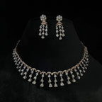 A gold diamond necklace with a series of round and marquise shaped earrings attached to the neckline, set on a black mannequin.