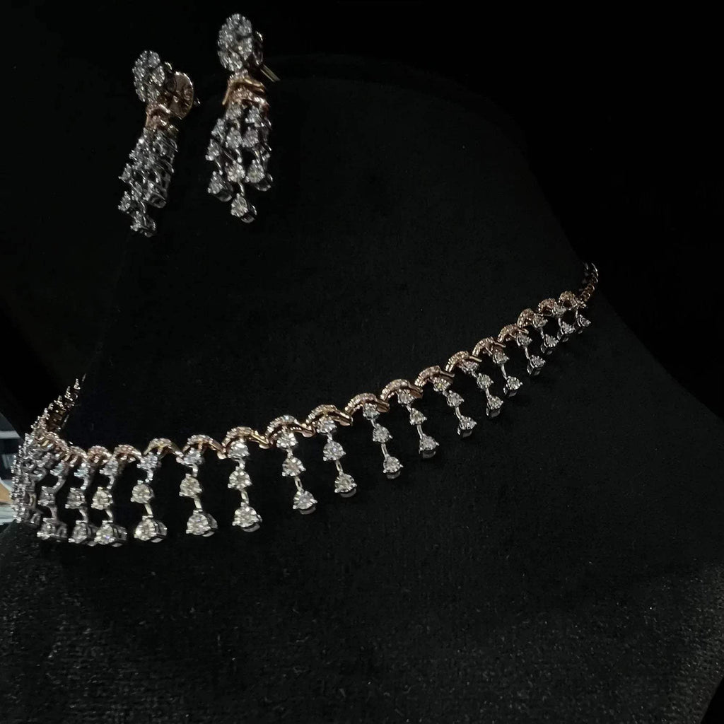 A gold diamond necklace with a series of round and marquise shaped earrings attached to the neckline, set on a black mannequin.