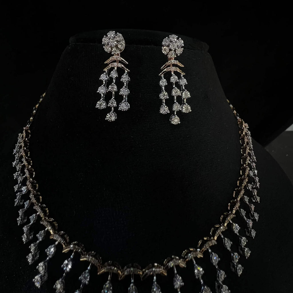 A gold diamond necklace with a series of round and marquise shaped earrings attached to the neckline, set on a black mannequin.