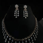 A gold diamond necklace with a series of round and marquise shaped earrings attached to the neckline, set on a black mannequin.