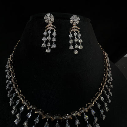 A gold diamond necklace with a series of round and marquise shaped earrings attached to the neckline, set on a black mannequin.