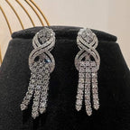 Eternal Knot Cascade diamond necklace set with matching earrings featuring layered diamond strands displayed on a mannequin.