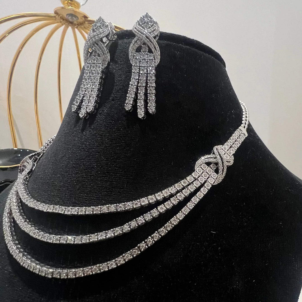 Eternal Knot Cascade diamond necklace set with matching earrings featuring layered diamond strands displayed on a mannequin.