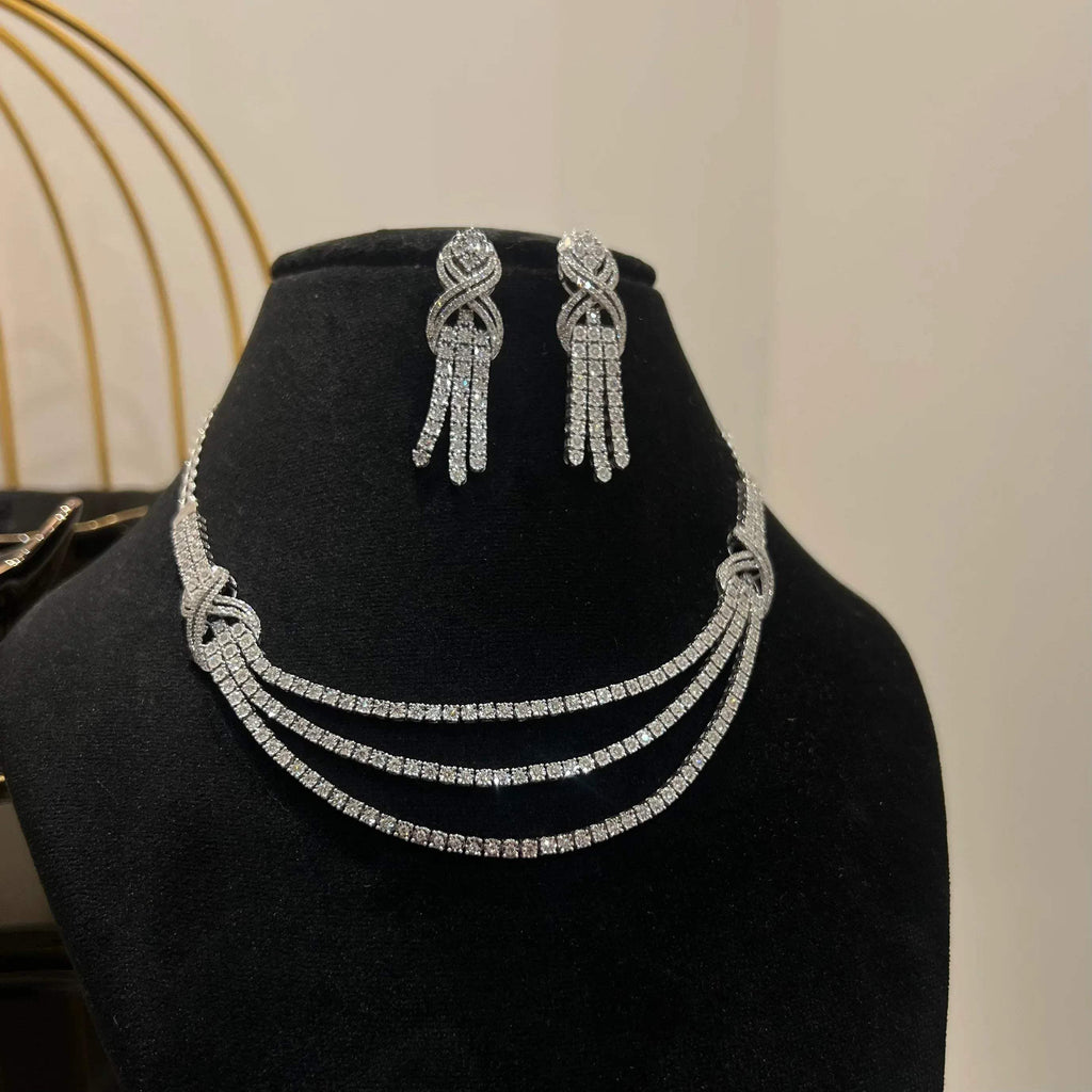Eternal Knot Cascade diamond necklace set with matching earrings featuring layered diamond strands displayed on a mannequin.