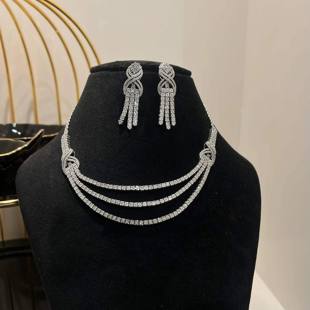 Eternal Knot Cascade diamond necklace set with matching earrings featuring layered diamond strands displayed on a mannequin.