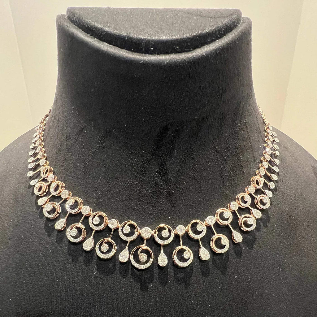 A gold diamond necklace and earrings set displayed on a mannequin bust, featuring a floral design with intricate detailing and adorned with genuine diamonds.