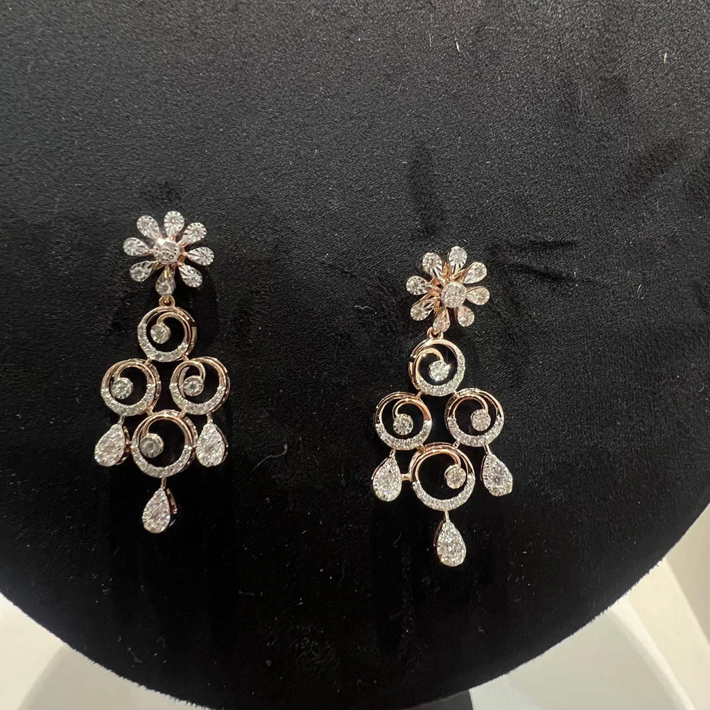gold diamond earrings displayed on a mannequin bust, featuring a floral design with intricate detailing and adorned with genuine diamonds.