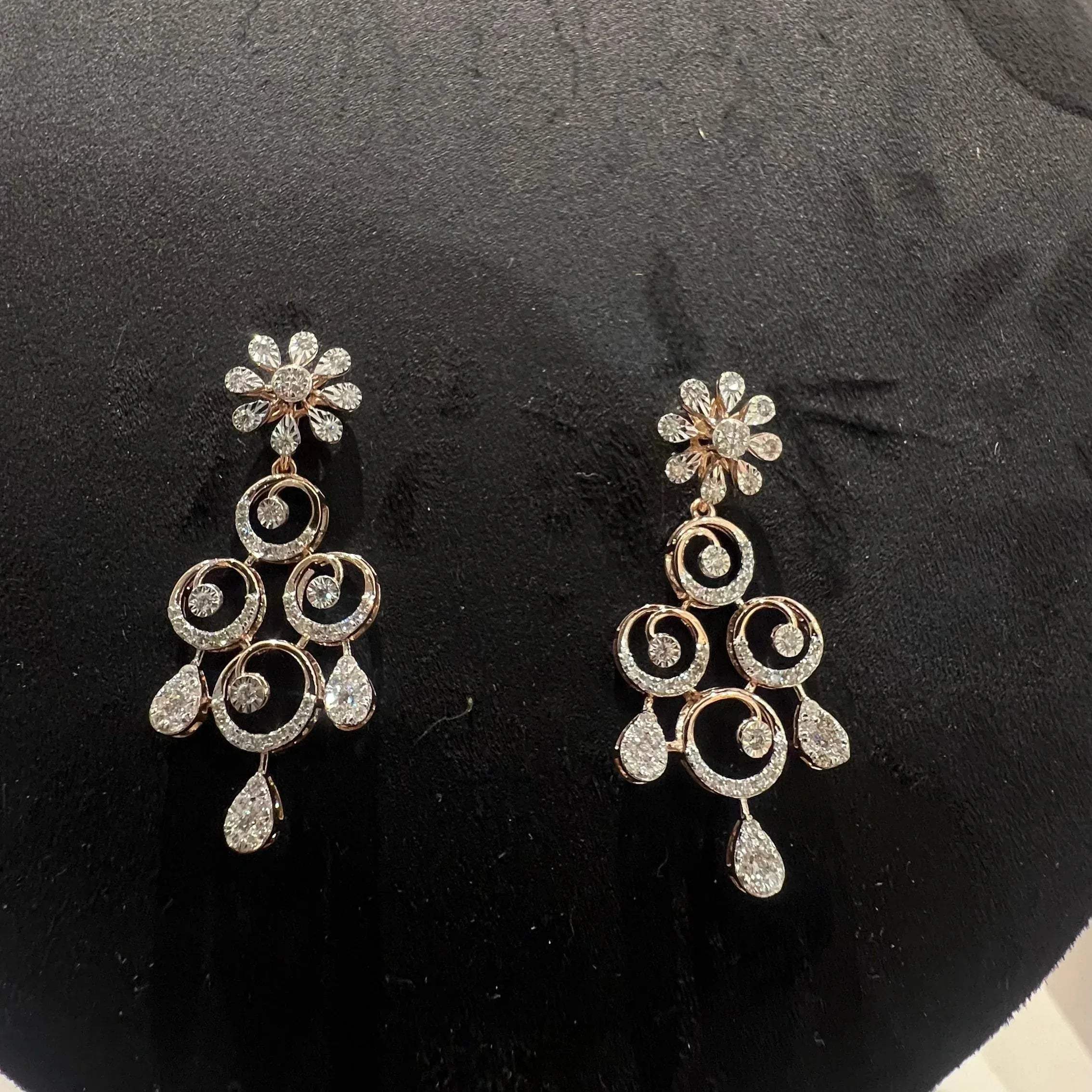 A gold diamond necklace and earrings set displayed on a mannequin bust, featuring a floral design with intricate detailing and adorned with genuine diamonds.