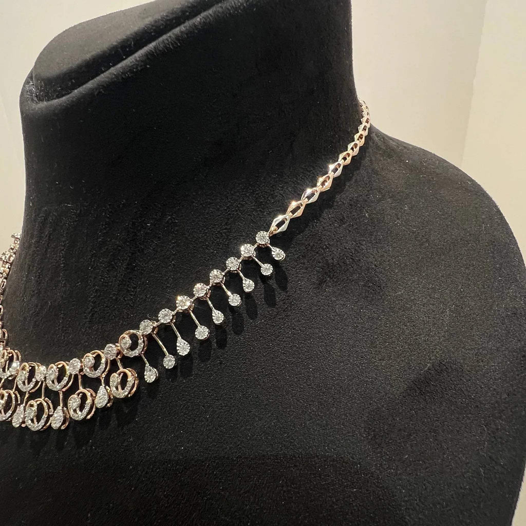 A gold diamond necklace displayed on a mannequin bust, featuring a floral design with intricate detailing and adorned with genuine diamonds.
