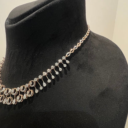 A gold diamond necklace displayed on a mannequin bust, featuring a floral design with intricate detailing and adorned with genuine diamonds.