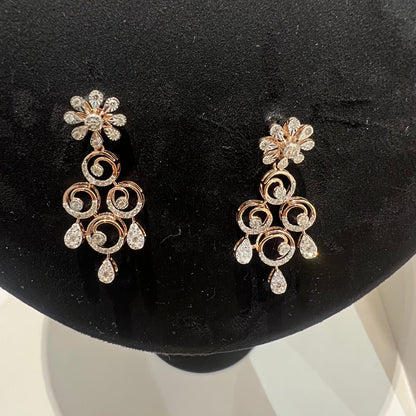 gold diamond earrings displayed on a mannequin bust, featuring a floral design with intricate detailing and adorned with genuine diamonds.